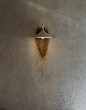 A minimalist wall lamp casting a soft glow on a textured surface, creating a serene ambiance.